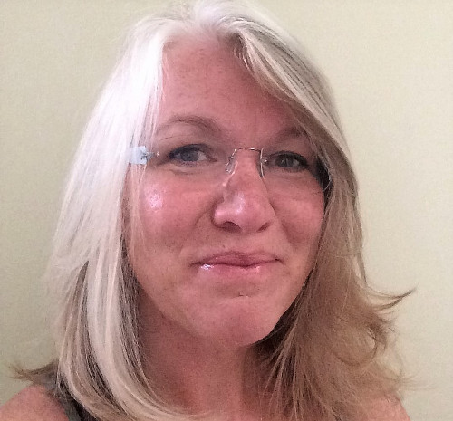 Headshot of woman with white hair and glasses